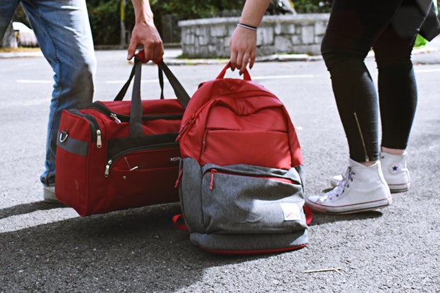červený batoh a cestovní taška
